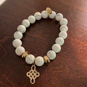 white beaded bracelet with gold charm